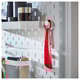 Bright red SNÖSKYFFEL shoehorn hangs on white organizer, featuring sturdy metal design.