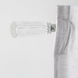 Modern wall-mounted curtain rod, polished chrome and clear glass finials, sleek design.
