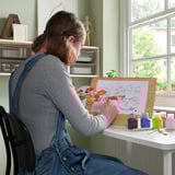 Person painting with acrylics on SOLFÅGEL easel.