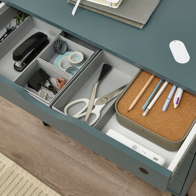 Organized office drawer with stationery, scissors, and a secure lock.