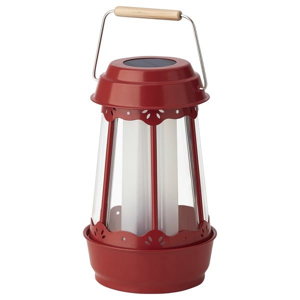 Red solar-powered lantern with wooden handle, clear glass sides, round shape, and decorative cutouts.