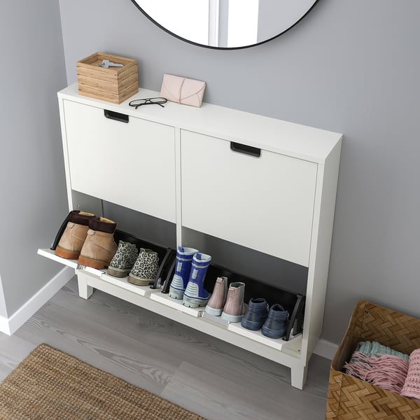White STÄLL shoe cabinet with 8 pairs, open front for ventilation, wooden legs, near wall mirror.