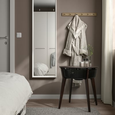 Modern bedroom with STARKVIND air purifier table, towel rack, gray walls, white linens, simplicity.