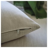 Close-up of beige cushions zipper on modern sofa, emphasizing comfort and removable cover.