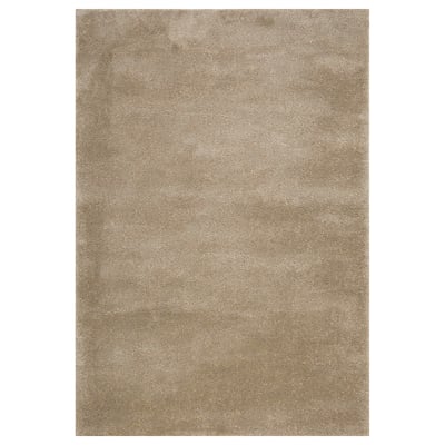 A beige STOENSE rug. Its rectangular, soft, with a slightly shiny surface. Ideal for large or small rooms, it dampens sound and feels cozy.