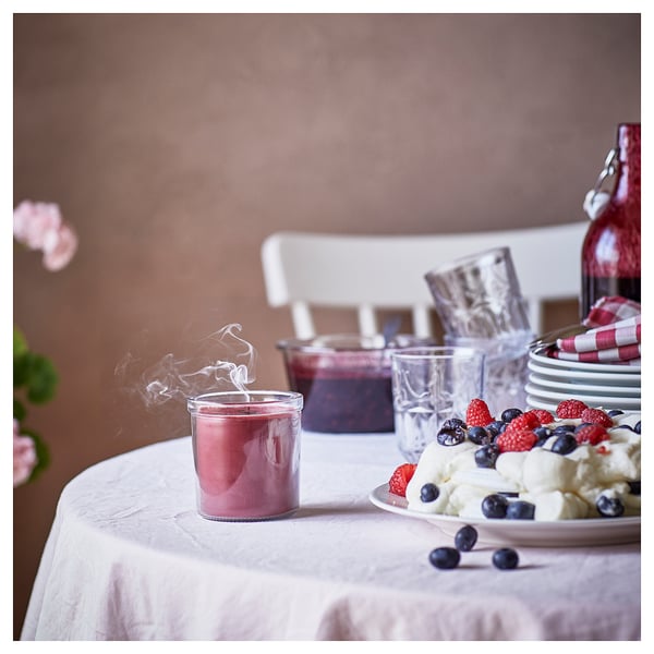 Cozy dinner table with STÖRTSKÖN candle, berries, and glassware.