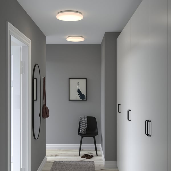 Modern entryway with gray walls, STOFTMOLN lamp, white wardrobe, black chair, and mirror.