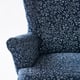 A wingback chair with dark blue patterned fabric featuring white floral designs, showcasing high-quality material and craftsmanship.