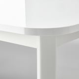White round table corner detail, smooth surface, sleek design.