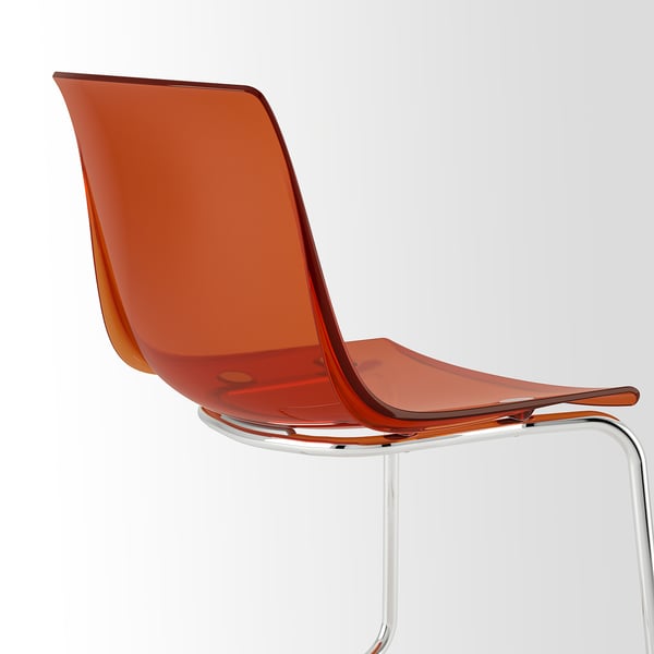 A transparent, orange chair with a chromed metal frame, offering a modern and sleek appearance.