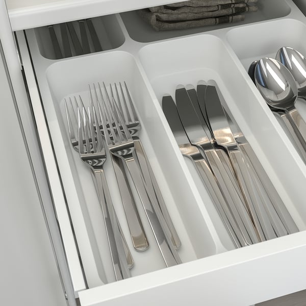 Silverware organizer with forks, knives, and spoons in compartments.