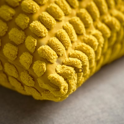 Yellow square cushion cover with rounded bumps, textured design, soft material.
