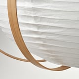 Description: modern, circular pendant lamp with sleek bamboo ribs holding a soft, white rice paper shade, casting a gentle glow.