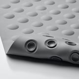 Gray shower mat with suction cups. Textured surface for grip. Holes for hanging.