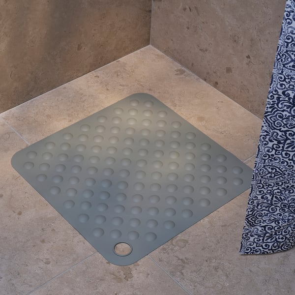 Square gray shower mat with suction cups, designed for non-slip safety.