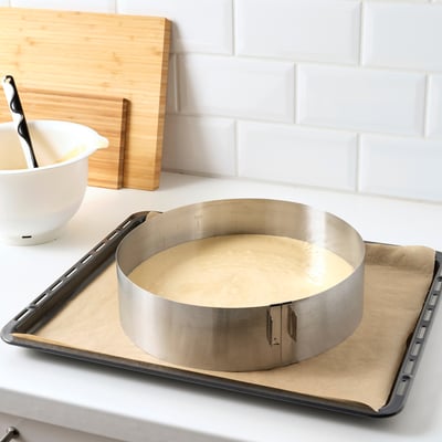Baking frame adjusts size for round cakes, shows measurements, fits in oven and freezer.