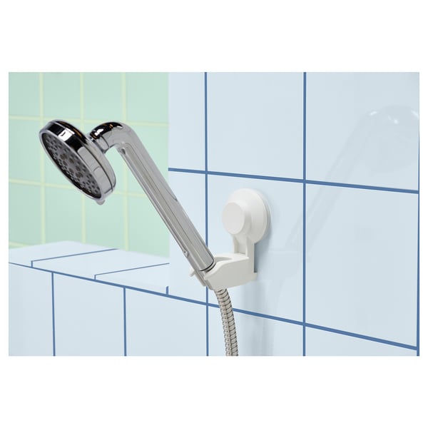 Image TISKEN shower holder in white, mounted on a tiled wall, holding a chrome showerhead.