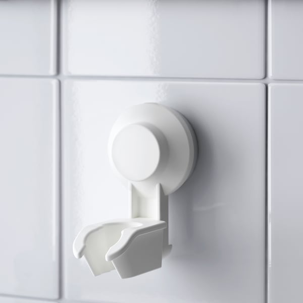 White suction cup shower holder mounted on glossy tiles, securely gripping empty holder in perfect condition.