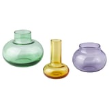 Three colorful glass vases in green, yellow, and purple, each with unique shapes, arranged together.