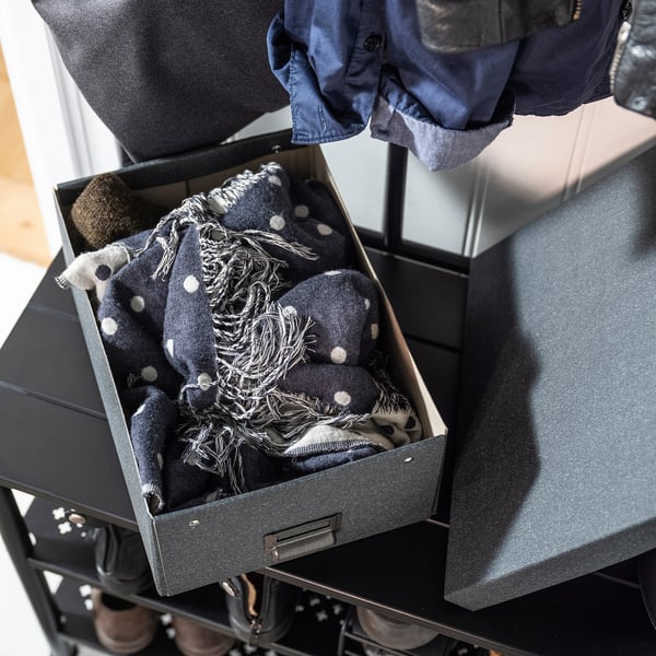 Black TJOG storage box with polka dot scarf, positioned in sturdy rack, holding clothing accessories.