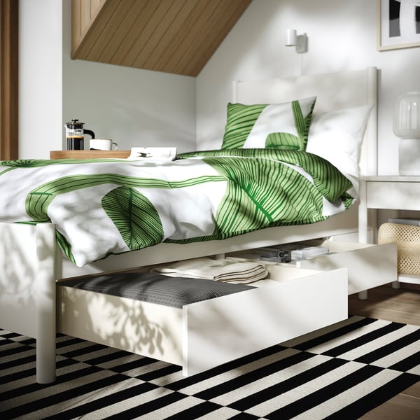 Modern bed with drawers, off-white. Green leaf bedding, coffee tray, open drawer under soft close.