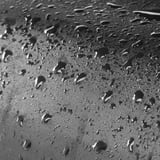 Water droplets glisten on waterproof surface. This protective cover keeps outdoor furniture dry, organized, and durable.
