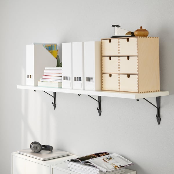 Wall-mounted shelf displaying books, a wooden box, and decorative items. Efficiently organizes and items on a white wall.