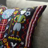 Vibrant cushion cover with intricate folk art, depicting people and nature. Rich colors, detailed design. Zipper closure.