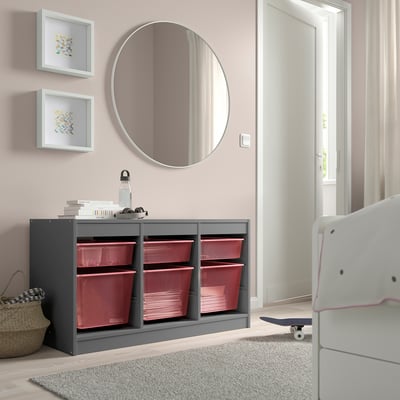 Grey TROFAST unit with pink baskets, mirror, white chair, skateboard.