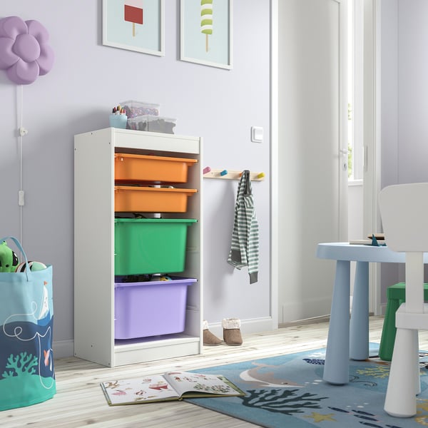 White TROFAST storage unit with colorful bins. Easy kids reach, fits toys & books. Purple, green, orange bins. Small, near play area.