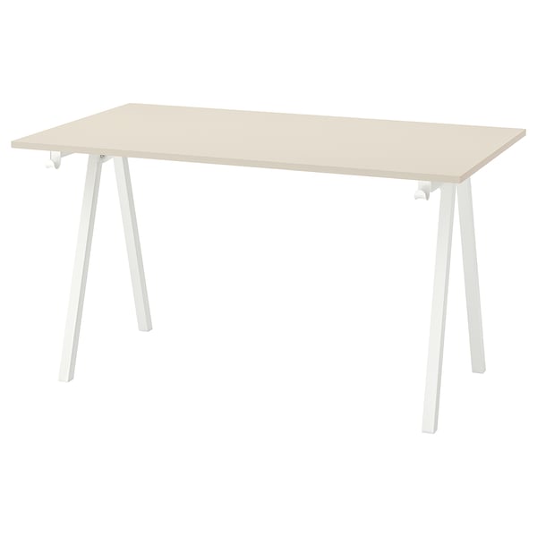 A trottem table with a beige top and white legs.