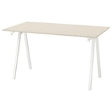 A trottem table with a beige top and white legs.
