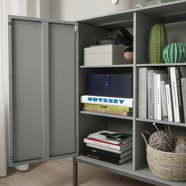 Modern gray metal TULLSTORP sideboard with open and closed storage, displaying books, boxes, and decor. One door open, revealing organized shelves.