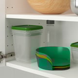 White shelf with plastic storage containers. Green-lidded clear container and green bowl with orange trim shown.