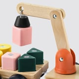 Wooden toy crane lifting magnet block with other colorful blocks.