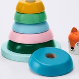 Bright, durable plastic stacking rings in pastel colors, laid neatly with one ring off to side, showcasing quality and design for childrens play.