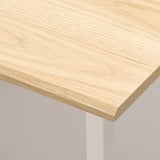 Close-up of smooth, light wood tabletop corner, showcasing quality finish.