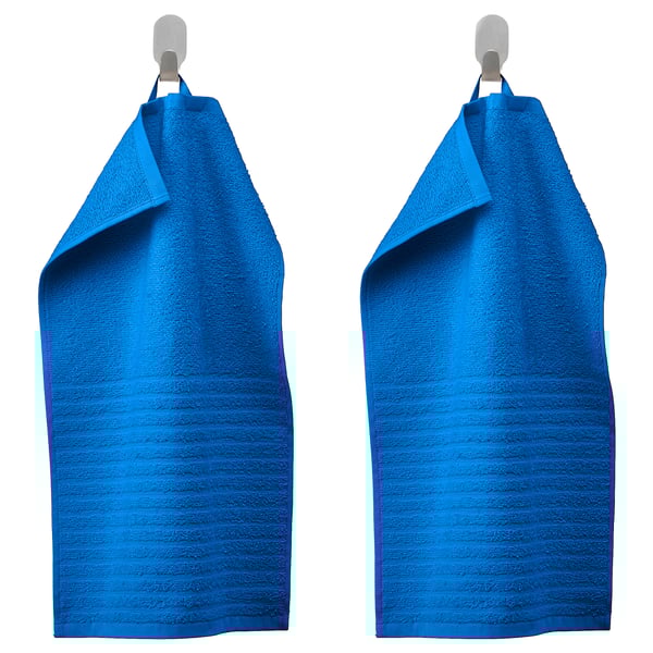 Two blue VÅGSJÖN towels hang neatly from silver hooks, showcasing their textured, ribbed design and soft cotton material.