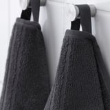 Black towels hanging: soft, absorbent cotton; medium weight, quick-dry stripes.