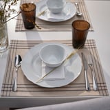 Two table settings with white dishes, silverware, brown cups, and beige place mats.