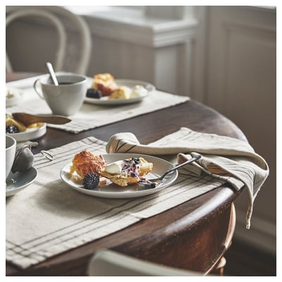 Cozy breakfast with scone, coffee, and pastries on beige mat.