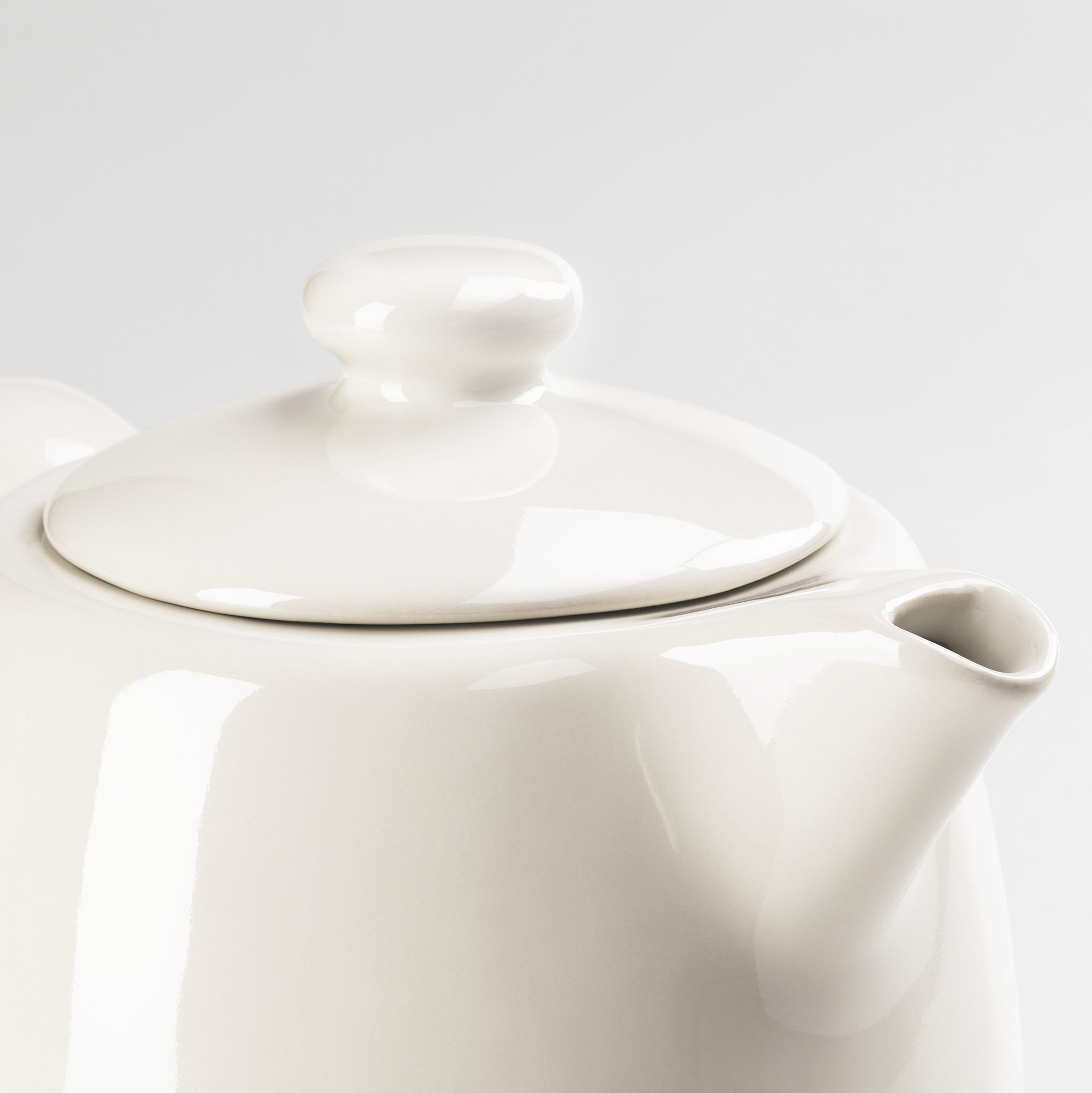 Shiny white teapot with smooth handles.
