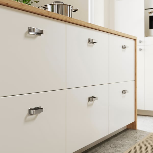 Modern kitchen with VEDDINGE white cabinets and chrome handles.