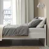 Minimalist bed with clean lines, neutral bedding, storage solutions.