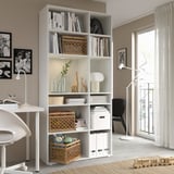 Modern home office white VIHALS storage unit, books, toys, and desk near a window.
