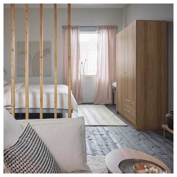 Bedroom with VILHATTEN wardrobe, light wood, minimalist design. Curtains, rug, and cushions.