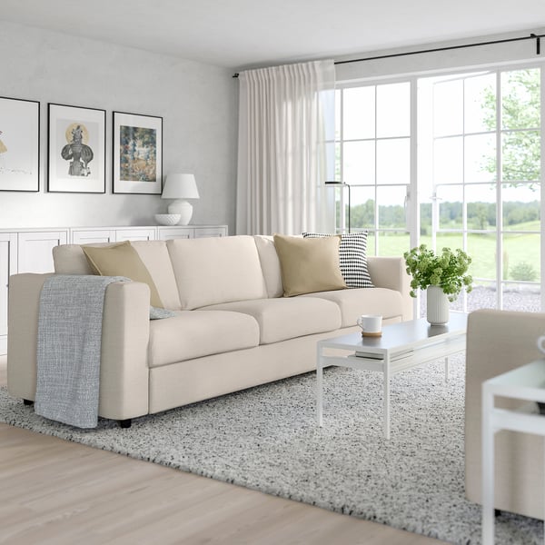 Beige VIMLE sofa-bed in living room with cushions, coffee table, and large windows.