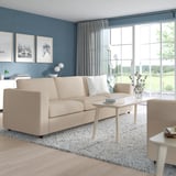 Minimalist living room with white VIMLE sofa-bed, coffee table, and green view.