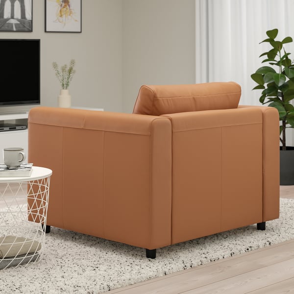 Brown leather chair near a white side table with a mug.