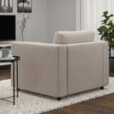 Gray armchair from VIMLE series on rug, side table with mug & decor.